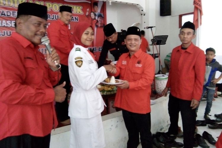 Fahrudin Bisri Slamet,  Ketua DPC PDIP Kabupaten Demak, Jateng, memberikan potongan tumpeng kepada salah satu kader muda partai, pada perayaan ulang tahun ke-45 PDI-P di Kantor DPC PDIP Demak, Minggu (14/1/2018).