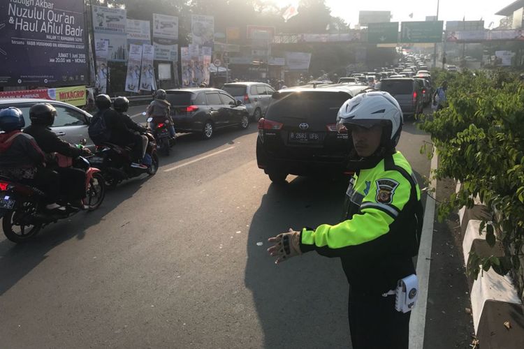 Petugas kepolisian mengatur arus lalu lintas di Simpang Gadog, Ciawi, Puncak, Bogor, Jawa Barat, Sabtu (16/6/2018).