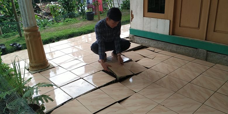 Seorang warga menunjukkan retakan di lantai dampak bencana gerakan tanah di Desa Kertaangsana, Nyalindung, Sukabumi, Jawa Barat, Senin (22/4/2019)