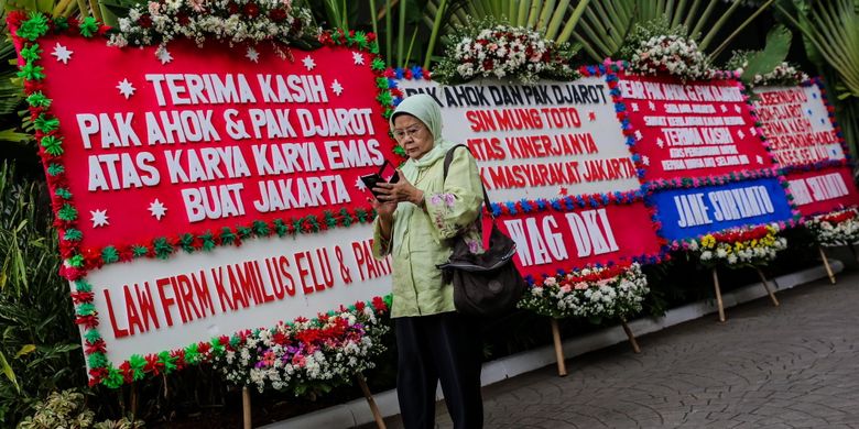 Warga berdiri di antara karangan bunga yang ditujukan untuk Basuki Tjahaja Purnama atau Ahok dan Djarot Saiful Hidayat di kompleks Balai Kota DKI Jakarta, Senin (9/10/2017). Karangan bunga tersebut berisi ucapan terima kasih dari warga atas kepemimpinan Basuki dan Djarot selama berpasangan menjadi gubernur dan wakil gubernur DKI Jakarta.
