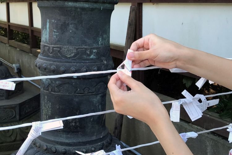 Lalu selipkan salah satu ujung kertas masuk ke dalam simpul. 
