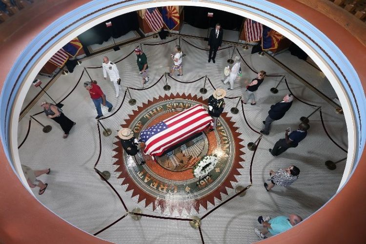 Masyarakat melihat peti mati Senator John McCain saat jenazahnya dibawa ke Arizona State Capitol Rotunda  pada Rabu (29/8/2018) di Phoenix, Arizona. (AFP)