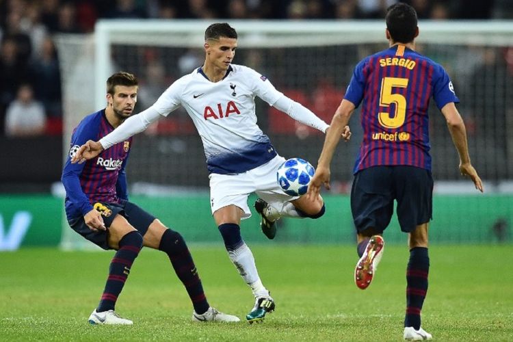 Erik Lamela melepas tembakan meski dikawal Gerard Pique dan Sergio Busquets saat Tottenham Hotspur vs Barcelona beradu dalam lanjutan Liga Champions di Stadion Wembley, 3 Oktober 2018. 