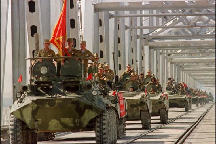 Konvoi kendaraan lapis baja pasukan Uni Soviet melintasi jembatan di perbatasan Soviet-Afghanistan saat mereka memutuskan menarik diri dari Afghanistan di Termez, Uzbekistan, pada 21 Mei 1988.