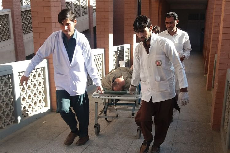Petugas medis membawa korban ledakan bom di pasar di Kohat, Pakistan, Jumat (23/11/2018).