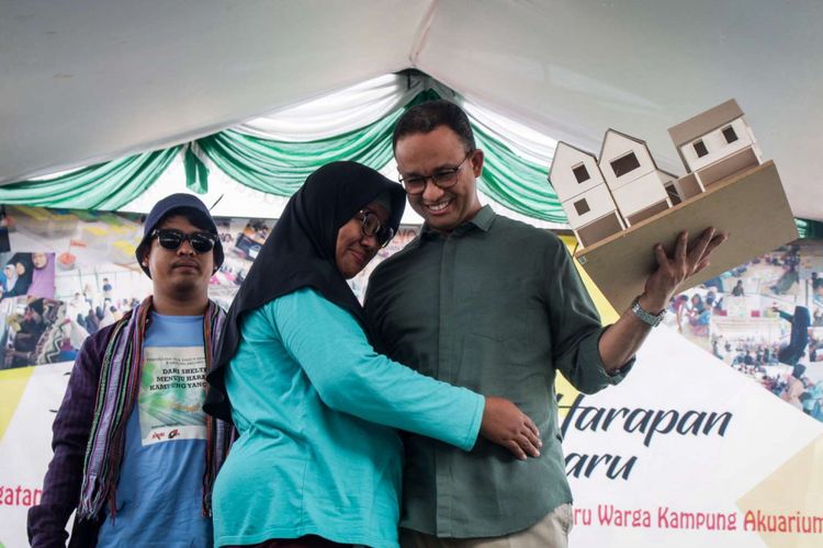 Gubernur DKI Jakarta Anies Baswedan (kanan) saat menerima simbolis desain rumah pada peringatan dua tahun penggusuran di Kampung Akuarium , Penjaringan, Jakarta, Sabtu (14/4/2018). Peringatan yang  bertajuk Dari Shelter Menuju Harapan Kampung yang Baru tersebut menampilkan pertunjukan warga kampung seperti musik dan tarian daerah.