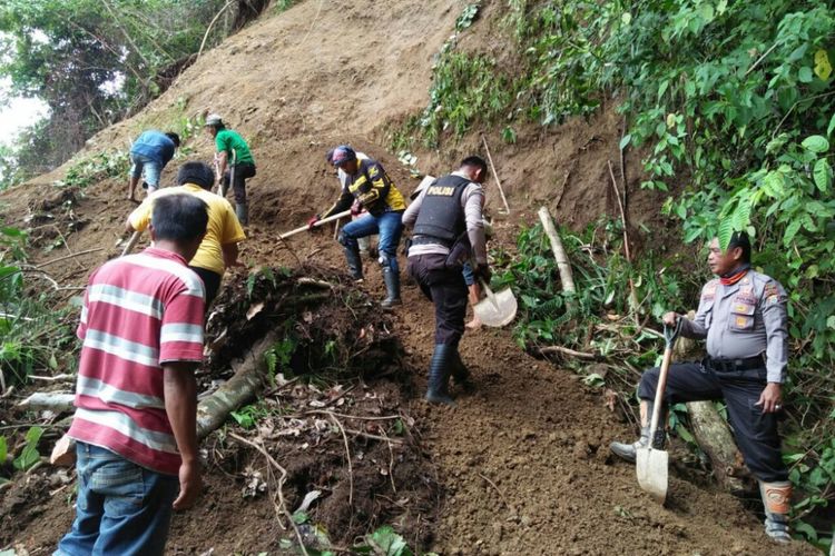 Aparat Polsek Bastem dan warga sekitar berupaya memindahkan runtuhan longsor yang menutupi akses Jalan Trans Sulawesi.