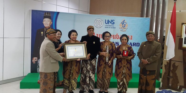 Rektor UNS Ravik Karsidi menyerahkan penghargaan  yang diterima oleh perwakilan putra-putri Sinuhun Paku Buana XII didampingi Ketua Senat UNS Suntoro (15/3/2019).