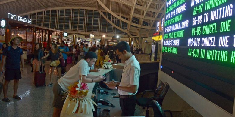 Calon penumpang menunggu jadwal penerbangan di Bandara Ngurah Rai Bali, Sabtu (25/11/2017) malam. Sebanyak 17 jadwal penerbangan internasional dari dan menuju Bali dibatalkan karena dampak erupsi Gunung Agung. 
