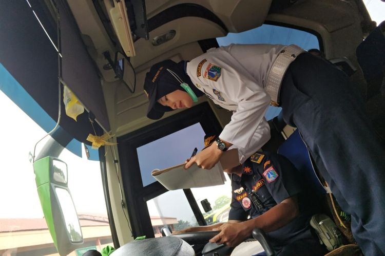 Dishub wanita tetap senyum manis di teriknya terminal Kampung Rambutan, Rabu (6/6/2018)