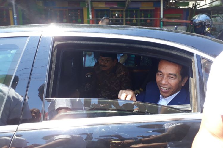 Jokowi dan Pakde Karwo bagi-bagi bingkisan dari dalam mobil.