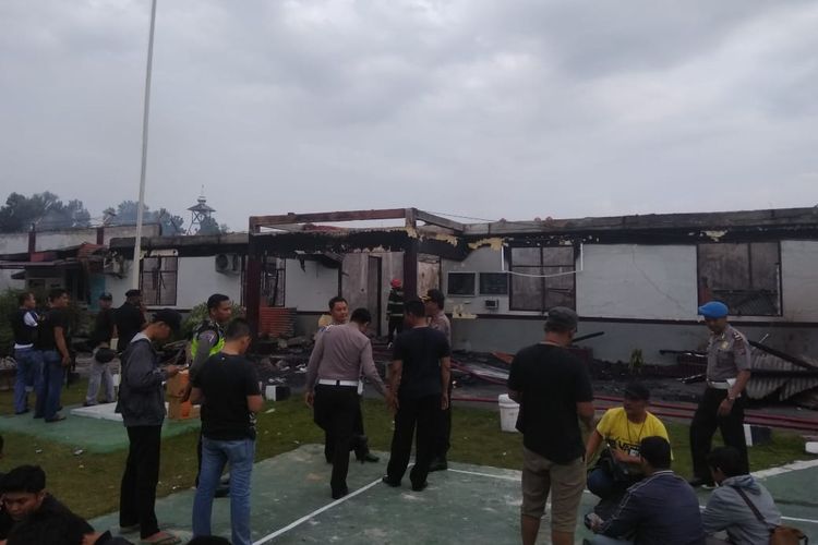 Petugas kepolisian melakukan pengamanan pasca-kerusuhan dan pembakaran Rutan Kelas IIB Siak Sri Indrapura, Riau,  Sabtu (11/5/2019) dini hari. 