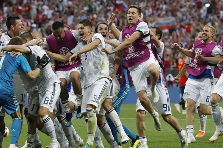 Para pemain Rusia berlari dan memeluk kiper Rusia Igor Akinfeev yang berhasil menggagalkan dua tendangan dalam adu penalti pada laga 16 besar Piala Dunia 2018 melawan Spanyol di Stadion Luzhniki, Minggu (1/7/2018). Timnas Rusia lolos ke babak perempat final setelah menyingkirkan Spanyol lewat drama adu penalti dengan skor 4-3.