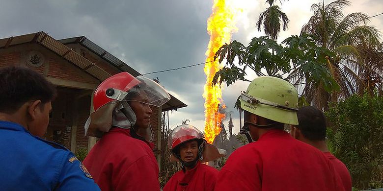 Petugas pemadam kebakaran berada di dekat lokasi kebakaran sumur minyak di Desa Pasi Putih, Kecamatan Ranto Peureulak, Kabupaten Aceh Timur, Rabu (25/4/2018). Sedikitnya 10 orang tewas dan belasan lainnya terluka akibat insiden meledaknya sumur minyak yang terjadi sekitar pukul 01.30 tersebut. .
