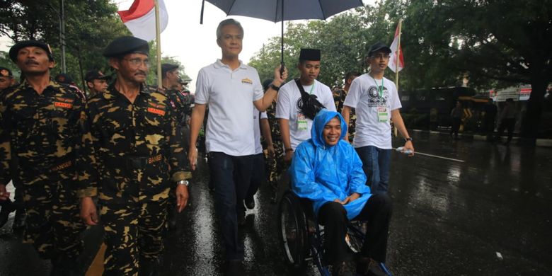 Gubernur Jawa Tengah Ganjar memayungi salah satu penyandang disabilitas pada Sabtu (23/2/2019). 