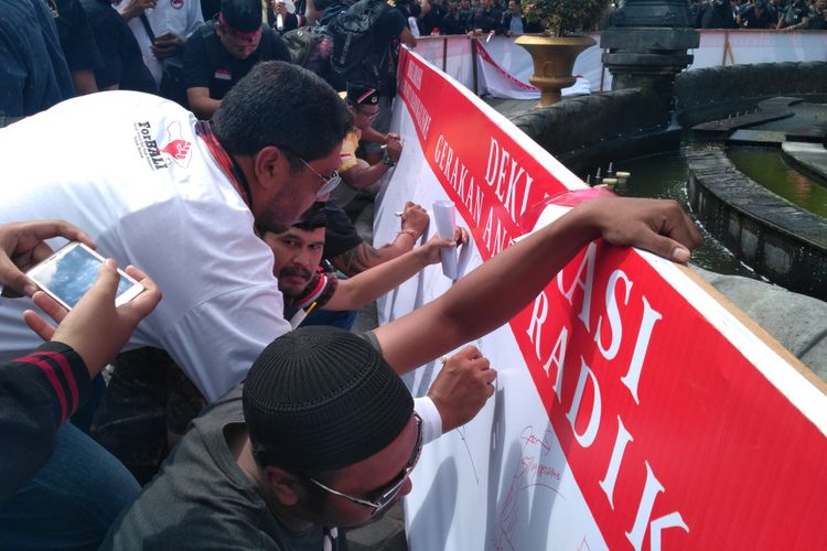 Warga Denpasar membubuhkan tanda tangan di atas kain sepanjang 100 meter sebagai bentuk penolakan pada radikalisme