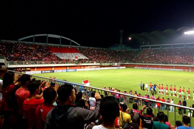 Suporter bentangkan bendera Merah Putih saat laga Timnas Indonesia melawan Timnas Puerto Rico yang digelar di stadion Maguwoharjo, Sleman