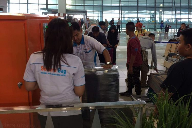 Pemudik memilih untuk wrapping tas dan koper bawaan mereka saat hendak berangkat dari Terminal 3 Bandara Soekarno-Hatta, Tangerang, Kamis (22/6/2017).