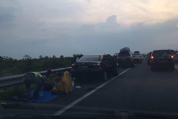 Sejumlah pemudik yang tak lagi bisa tertampung di tempat istirahat (rest area) Tol Cipali, Sabtu (1/7/2017) petang, memilih beristirahat di bahu jalan.