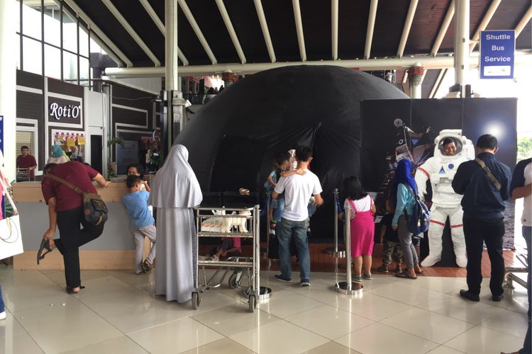 Pengunjung Bandara Soekarno-Hatta menikmati pertunjukkan visual melalui Mobile Planetarium yang disediakan di Terminal 1C, Minggu (20/8/2017). Mobile Planetarium diadakan sebagai sarana edukasi dan hiburan bagi pengunjung bandara, terutama anak-anak.