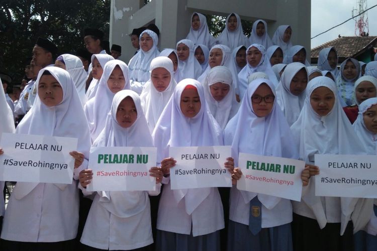 Para pelajar NU membentangkan poster yang bertuliskan #SaveRohingnya seusai menggelar shalat gaib untuk para korban tragedi kemanusiaan etnis Rohingya di wilayah Rakhine, Myanmar, Selasa (5/9/2017) siang. 