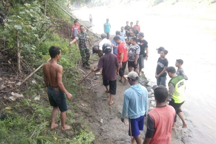 GOTONG--Warga menggotong mayat Kimun (89) yang ditemukann tewas dipinggir Sungai Bengawan Solo setelah dua minggu menghilang dari rumahnya, Minggu (29/10/2017)