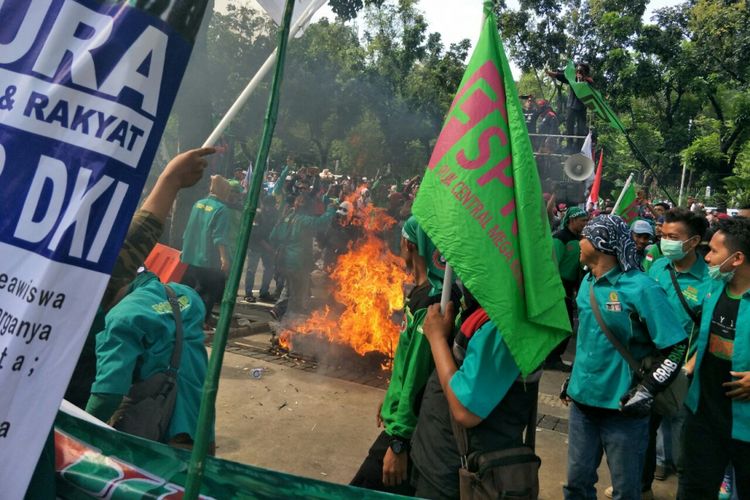 Massa buruh membakar keranda di depan Balai Kota DKI Jakarta, Jalan Medan Merdeka Selatan, Jumat (10/11/2017)