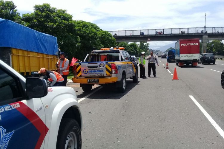 Petugas kepolisian mengevakusi korban meninggal dalam peristiwa tabrakan beruntun yang melibatkan tig kendaraan di Tol Jagorawi KM 30+400, Jumat (24/11/2017).