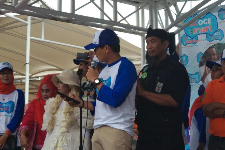 Wakil Gubernur DKI Jakarta Sandiaga Uno dipijat saat memberi sambutan di Taman Kota Intan, Jakarta Barat, Minggu (31/12/2017).