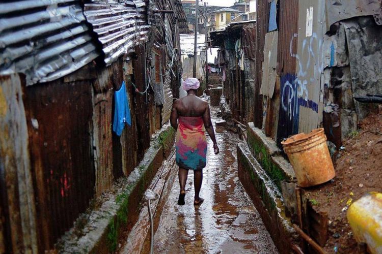 Seorang wanita berjalan di tengah perkampungan kumuh di Freetown, ibu kota Sierra Leone, di mana ratusan orang tewas akibat wabah ebola.  
