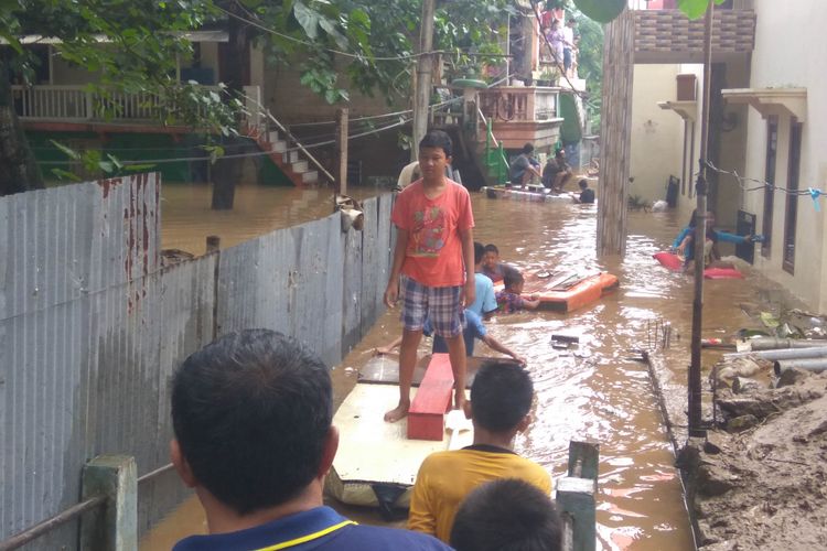 Anak-anak di jalan Arus mengojek sampan karena tidak bisa sekolah akibat banjir, Selasa (6/2/2018)