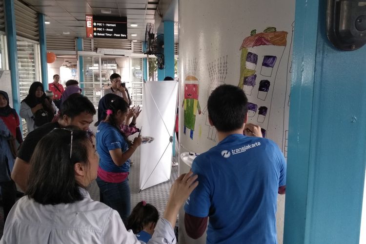 Anak-anak disabilitas dari yayasan Art Brut melukis dinding halte Transjakarta Kampung Melayu, Selasa (27/3/2018)