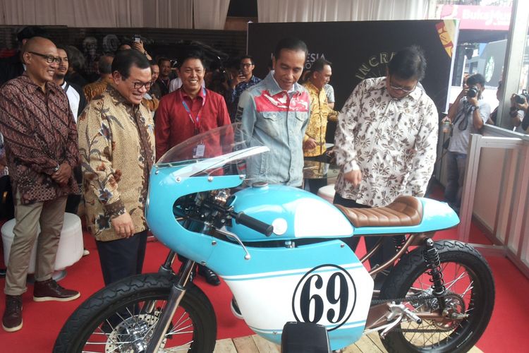 Presiden Joko Widodo mengamati salah satu sepeda motor Honda CB 125 lawas yang dipamerkan di stan Increase saat berlangsungnya hari pertama pameran Indonesia International Motor Show (IIMS) 2018, di JIExpo Kemayoran, Jakarta, Kamis (19/4/2018). Motor yang dimodifikasi bergaya caferacer merupakan milik putra sulung Jokowi, Gibran Rakabuming.