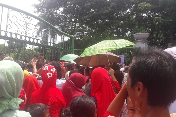 Ratusan warga berdesakan di pintu tenggara Monas untuk memperoleh sembako yang dibagikan dalam acara Untukmu Indonesia di Lapangan Monas, Jakarta Pusat, Sabtu (28/4/2018).