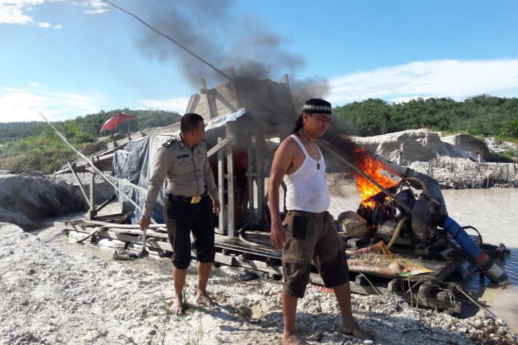 Petugas membakar rakit penambang emas ilegal yang ditemukan saat beroperasi di Kabupaten Kuansing, Riau.