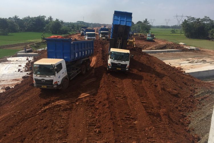Sejumlah truk mengangkut material pasir yang digunakan untuk menguruk Jembatan Sereng Baru pada pekerjaan Paket 3 Tol Pemalang-Batang, Sabtu (26/5/2018).