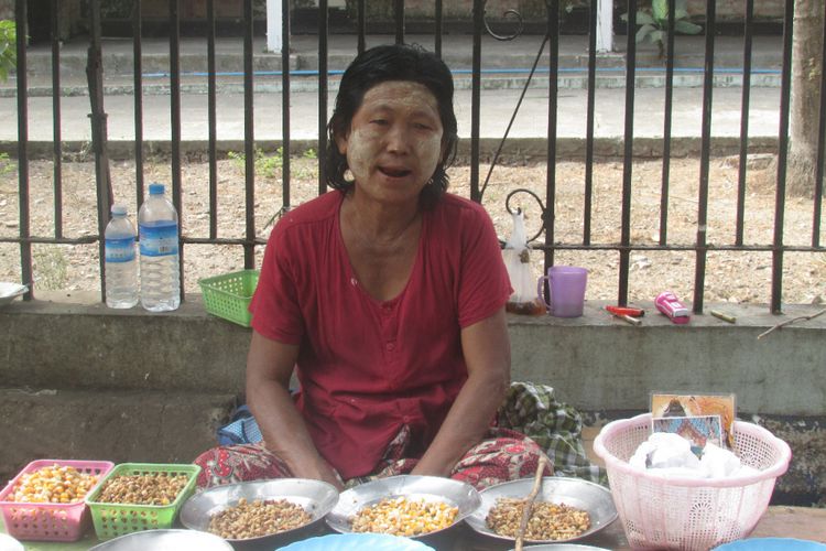 Seorang perempuan asal Myanmar berjualan jagung.
