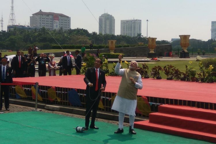 Joko Widodo dan Sri Narendra Modi tampak gembira ketika diminta memainkan layang-layang yang bergambar lambang 70 tahun persahabatan antara Indonesia dan India.
