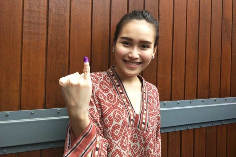 Ayu Ting Ting menunjukkan jari kelingking tangan kanannya yang sudah dicelupnya ke tinta tanda ia sudah menggunakan hak pilihnya untuk Pilkada Jawa Barat 2018 di TPS 5 Kelurahan Mekarjaya, Kecamatan Sukmajaya, Depok Jawa Barat, pada Rabu (27/6/2018). 

