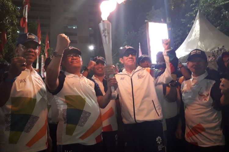 Menteri Hukum dan HAM Yassona Laoly menerima obor Asian Games 2018 dari Wali Kota Jakarta Utara Syamsuddin Lologau di halaman Kantor Wali Kota Jakarta Utara, Kamis (16/8/2018).