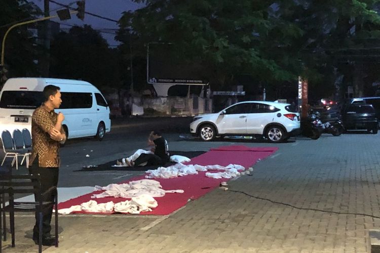 Para tamu hotel tidur di area parkir Hotel Aston Inn Mataram setelah gempa magnitudo 7 terjadi di Lombok, Minggu (19/8/2018).