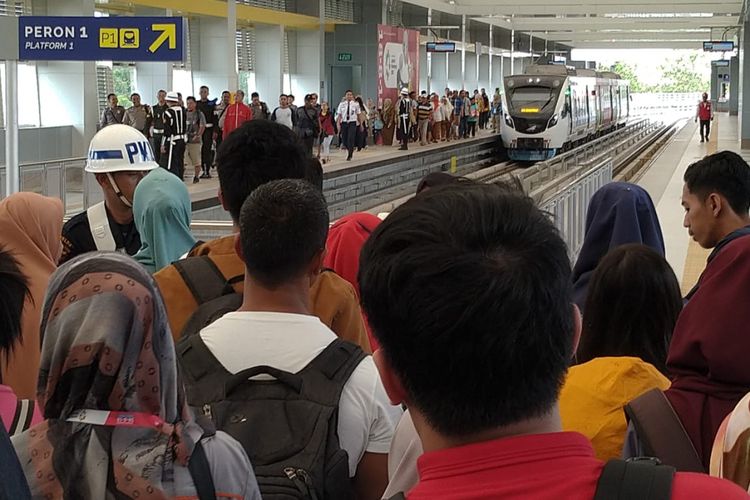 Penumpang yang berada di stasiun Bandara Sultan Mahmud Badaruddin II yang akan dipindah ke gerbong kereta lain, karena LRT kembali mengalami gangguan teknis, Senin (20/8/2018).