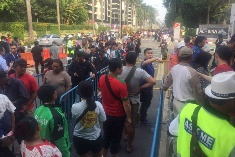 Antrean pembelian tiket final cabang olahraga badminton di ticket box badminton mengular di  Jalan Pintu I Gelora Bung Karno, Jakarta Pusat, Rabu (22/8/2018). Pantauan Kompas.com di lokasi, antren terlihat mengular dari ticket box di dekat Masjid Al Bina hingga ke lampu lalu lintas atau sekitar 500 meter.