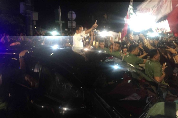 Jokowi  membuka pintu mobil sebelah kiri dan keluar mengacungkan jari telunjuknya tanda nomor pemilih 1 yang merupakan nomor perserta Pemilu Presiden 2019  bersama calon wakil presiden Maruf Amin, Jumat (21/9/2018). 