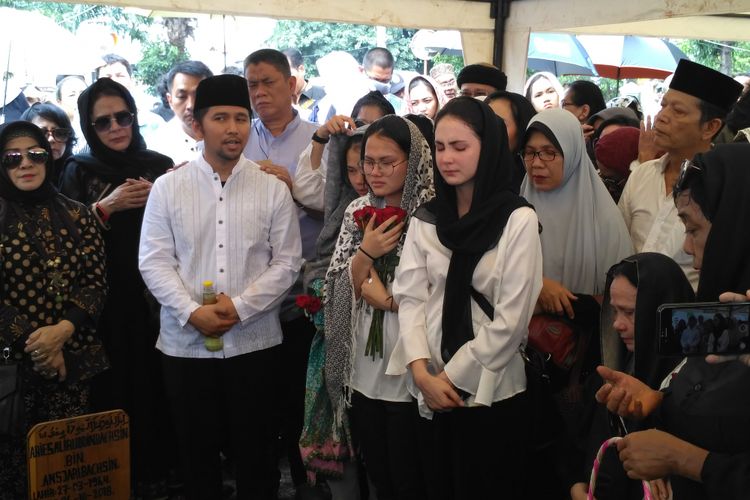 Arumi Bachsin (tengah) didampingi suaminya Emil Dardak (kiri) mengantarkan jenazah ayahanda Aries Aliruddin Bachsin, di TPU Kebon Nanas, Jakarta Timur, Jumat (26/10/2018). 