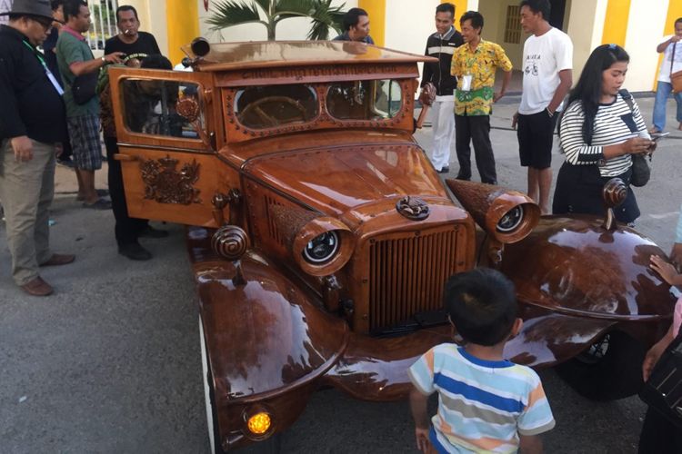 Edy Ban, pemilik mobil kayu asal Sumenep saat berpose di mobilnya di depan pintu masuk keraton Sumenep, Ahad (28/10/2018) lalu.