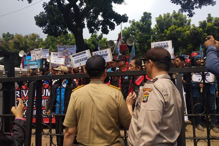 Massa buruh Federasi Serikat Pekerja (FSP) Logam, Elektronik, dan Mesin (LEM) Serikat Pekerja Seluruh Indonesia (SPSI) berunjuk rasa di depan Balai Kota DKI Jakarta, Selasa (18/12/2018). 