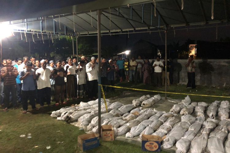 Warga sedang melakukan shalat jenazah terhadap korban tsunami yang ditemukan warga di dusun Lamseunong, Kajhu, Aceh Besar. BPBA menyebutkan sebanyak 45 jenazah ditemukan..