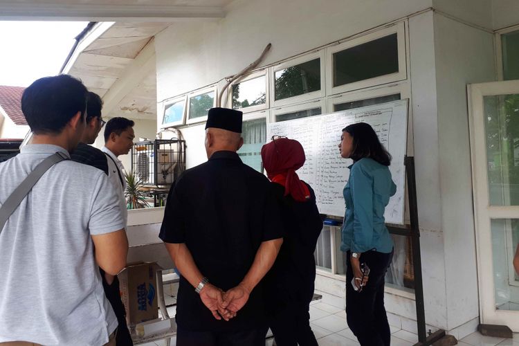 Kerabat korban tsunami Selat Sunda saat melihat daftar jenazah yang masuk ke RSUP Fatmawati, Jakarta Selatan, Senin (24/12/2018).