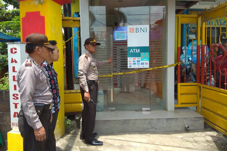 Petugas Polsek Pare Kabupaten Kediri, Jawa Timur memasang garis polisi pada bilik ATM lokasi pembobolan.